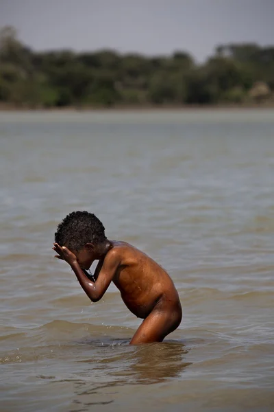 El chico africano lavándose en el río . —  Fotos de Stock