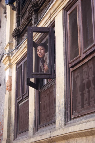 Frau schaut aus dem Fenster zu — Stockfoto