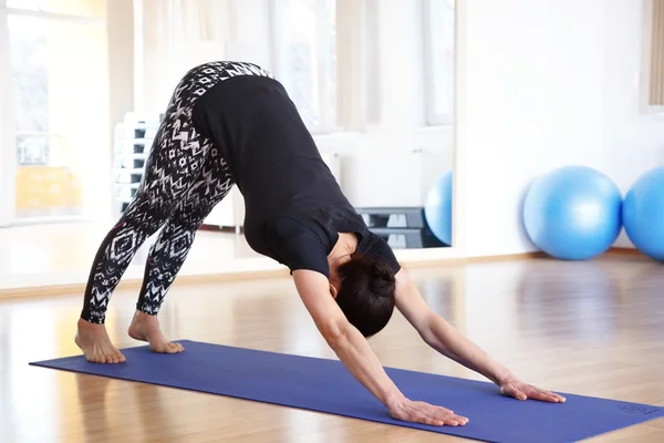 Mujer en una pose de yoga en el estudio —  Fotos de Stock