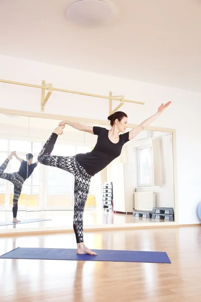 Mujer de pie en una pose de yoga —  Fotos de Stock