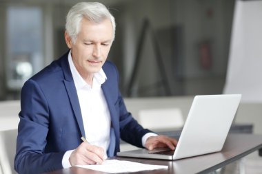 İşadamı laptopuyla çalışıyor.