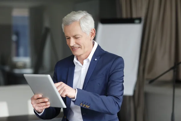 Senior obchodník pracuje na jeho digitálním tabletu — Stock fotografie