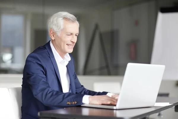 Senior-Geschäftsmann arbeitet an seinem Laptop — Stockfoto