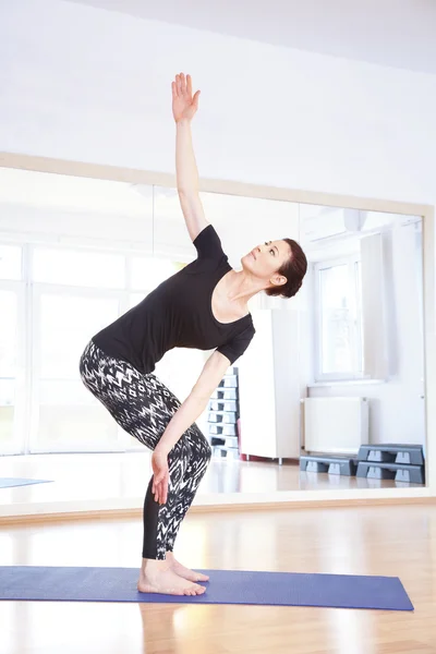 Vrouw in yoga vormen op yogastudio. — Stockfoto