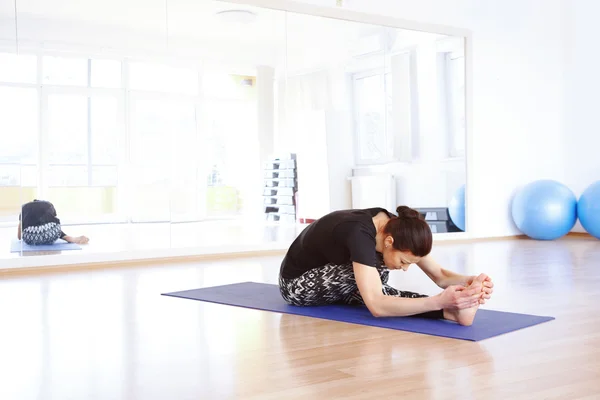 Vrouw in een pose yoga bij yogastudio. — Stockfoto