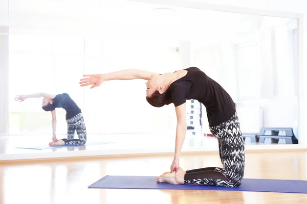 Mulher em uma pose de ioga no estúdio de ioga . — Fotografia de Stock