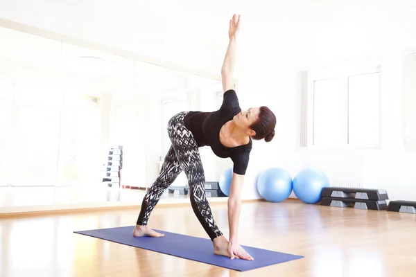 Vrouw in een pose yoga bij yoga — Stockfoto