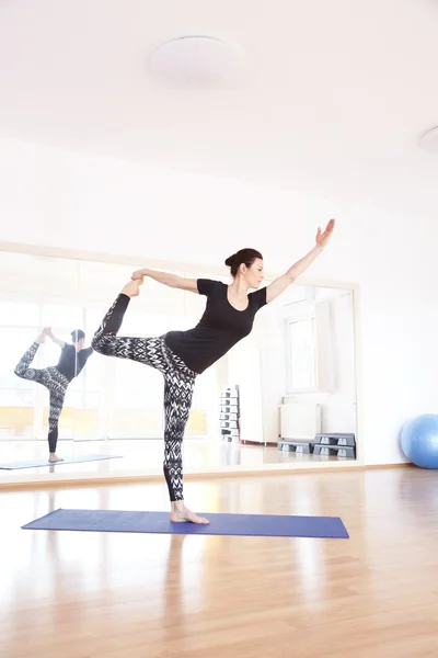 Vrouw doet yoga op een oefening mat — Stockfoto