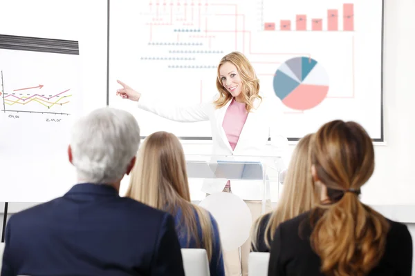 Empresaria dando una presentación a sus compañeros de trabajo — Foto de Stock