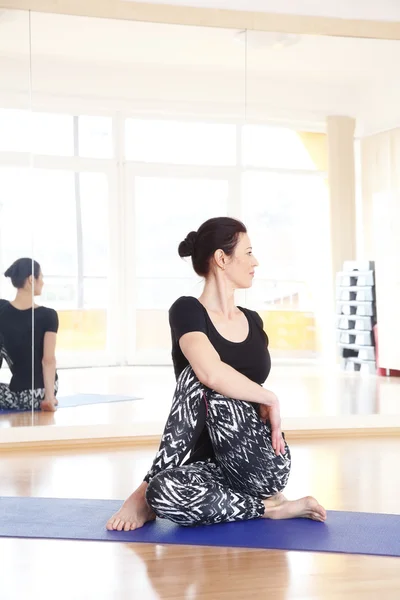 Vrouw doet yoga op een oefening mat — Stockfoto