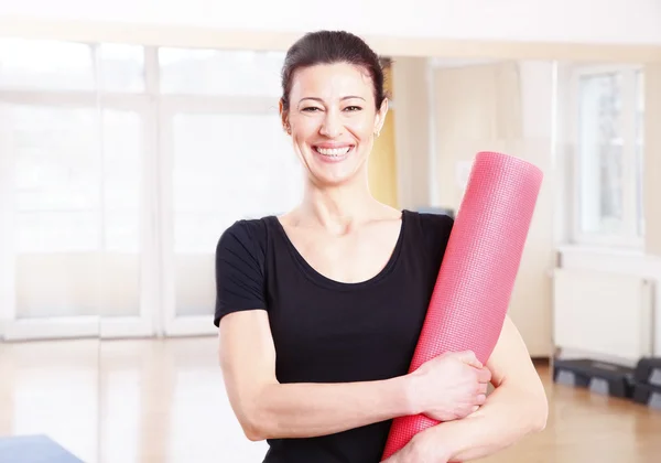 Yogalehrerin hält ihre Yogamatte — Stockfoto