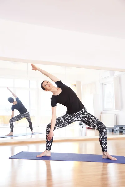 Жінка робить йогу на вправному килимку — стокове фото