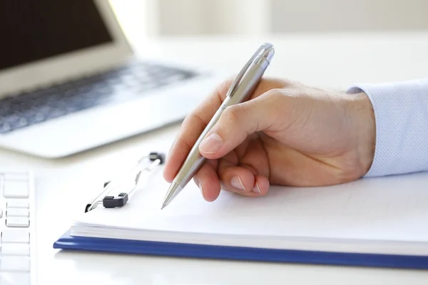 Geschäftsmann füllt Formular am Arbeitsplatz aus — Stockfoto