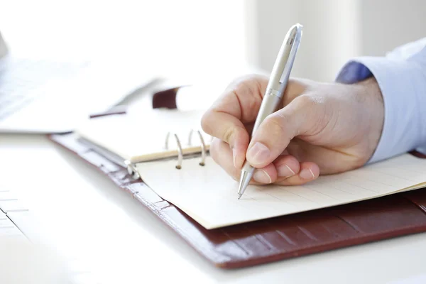 Empresario haciendo una lista a su diario — Foto de Stock