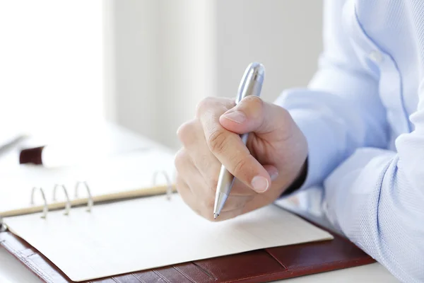 Geschäftsmann schreibt in ihr Tagebuch — Stockfoto