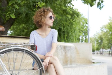 Onun Bisiklet yanındaki parkta oturan kadın