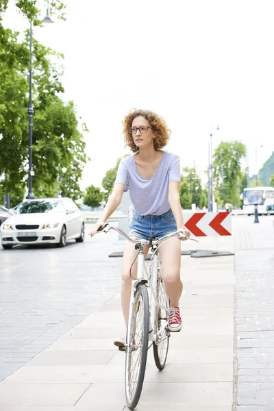 Женщина на велосипеде по городу — стоковое фото
