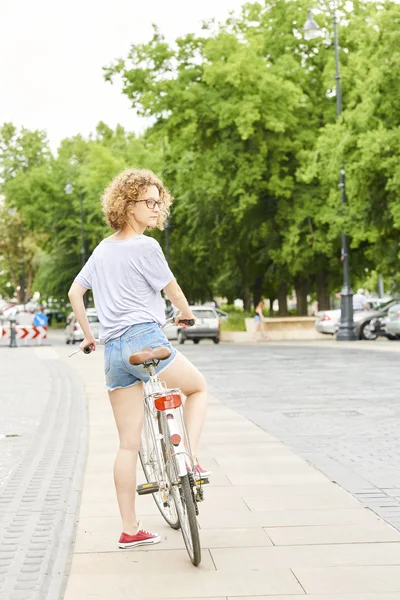 Woman with bike on the street — Stock Photo, Image