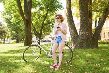 Parkta cep telefonu kullanan bir kadın. 