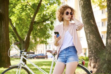 Parkta cep telefonu kullanan bir kadın. 