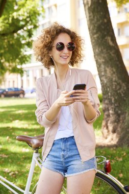 Parkta cep telefonu kullanan bir kadın. 