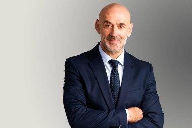 İzole edilmiş arka planda dururken takım elbise ve kravat giyen orta yaşlı işadamının stüdyo portresi.. 