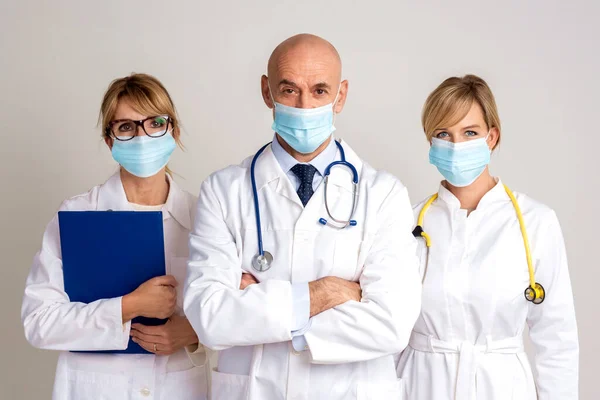 拍摄的女医生和男医生站在一起 在孤立的灰色背景下看着相机 医疗小组 医生戴口罩预防疾病 — 图库照片