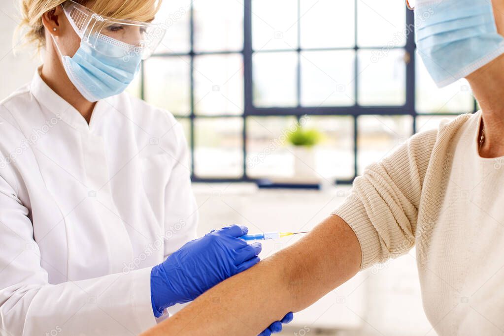 Cropped shot of woman getting vaccinated in the hospital.