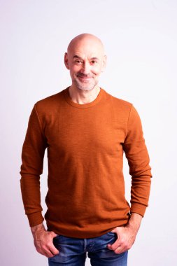 İzole edilmiş beyaz arka planda dikilirken sıradan kıyafetler giyen mutlu bir son sınıf öğrencisinin portresi. Boşluğu kopyala. 