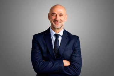 Gri arka planda dikilirken üst düzey yöneticilerin takım elbise giyip kravat taktığı görüntüler. Boşluğu kopyala. 