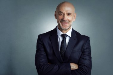 İzole edilmiş arka planda duran kendine güvenen iş adamının stüdyo portresi. 