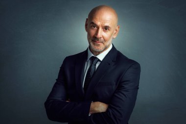 Stüdyoda gülümseyen işadamı takım elbise ve kravat giyerken kollarını kavuşturup izole arka planda dikilirken.. 