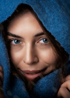 Güzel bir kadının portresi, mavi gözlü, kafasına atkı takmış kameraya bakıp gülümseyen.. 