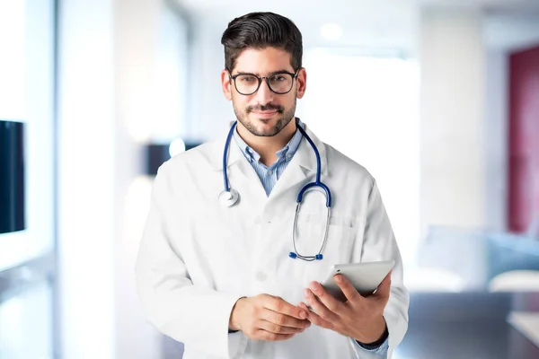 病院のホワイエに立っている間に彼の手にデジタルタブレットを保持男性医師のショット — ストック写真