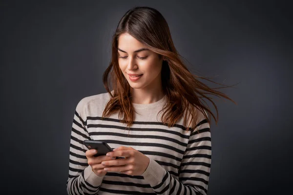 Studio Ritratto Della Donna Sorridente Utilizzando Smartphone Mentre Piedi Sfondo — Foto Stock