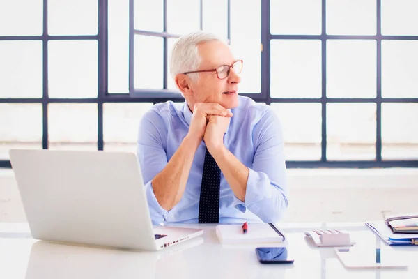 Tiro Hombre Negocios Senior Mirando Pensativamente Mientras Está Sentado Escritorio —  Fotos de Stock