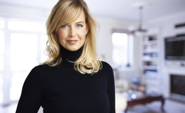 Çekici sarışın kadın portresi oturma odasında kameraya bakıp gülümsüyor.. 