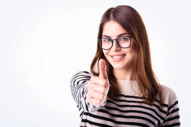 Genç bir kadının stüdyo portresi size onay veriyor. Beyaz arka planda izole edilmiş. Boşluğu kopyala. 