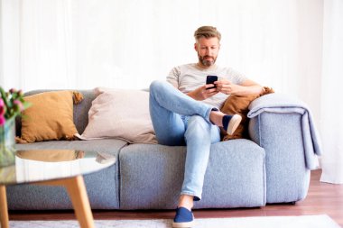 Evdeki kanepede oturan yakışıklı bir adamın fotoğrafı ve kısa mesaj.. 