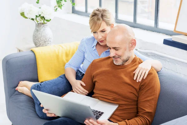 Smiling Middle Aged Couple Relaxing Sofa Home Together While Browsing — Stok Foto