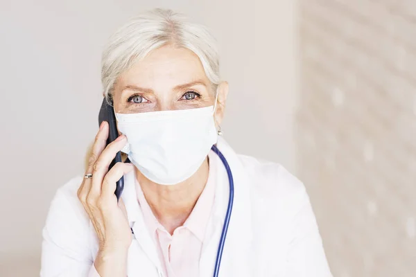 Skjuten Ledande Kvinnlig Läkare Bär Ansiktsmask Medan Har Ett Telefonsamtal — Stockfoto