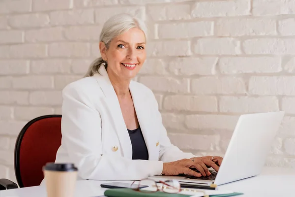 Tiro Mujer Negocios Mayor Sonriente Con Pelo Gris Sentado Escritorio —  Fotos de Stock