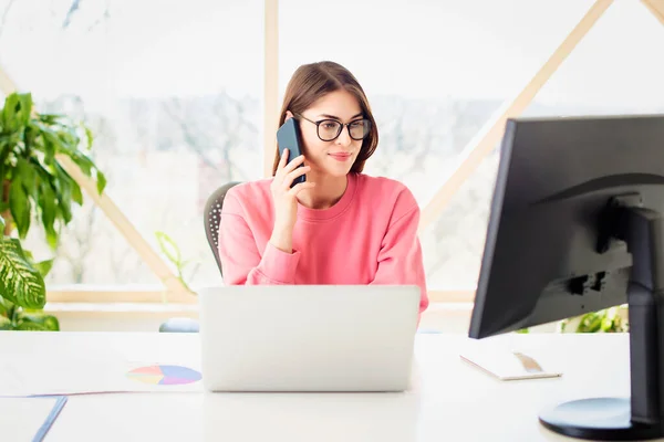 Joven Empresaria Sonriente Hablando Con Alguien Teléfono Móvil Usando Portátil —  Fotos de Stock