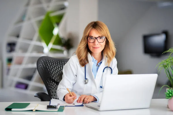 Gülümseyen Kadın Sağlık Çalışanı Doktorda Çalışırken Mesaj Atıyor Laptop Kullanıyor — Stok fotoğraf