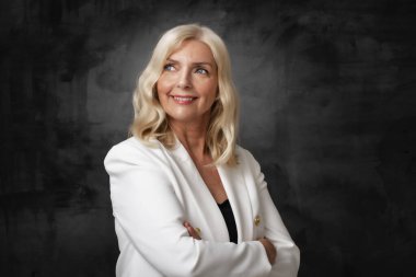 Stüdyo portresi gülen gri saçlı yaşlı kadın izole koyu gri arka planda duruyor. Boşluğu kopyala. 