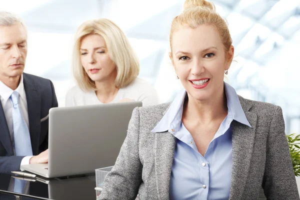 Businesswoman in office with colleagues — Stock Photo, Image