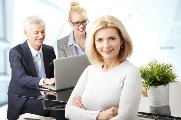 Businesswoman with colegas on background — Stock Photo, Image