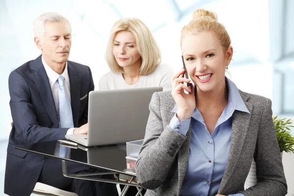 Empresaria con colegas en segundo plano — Foto de Stock