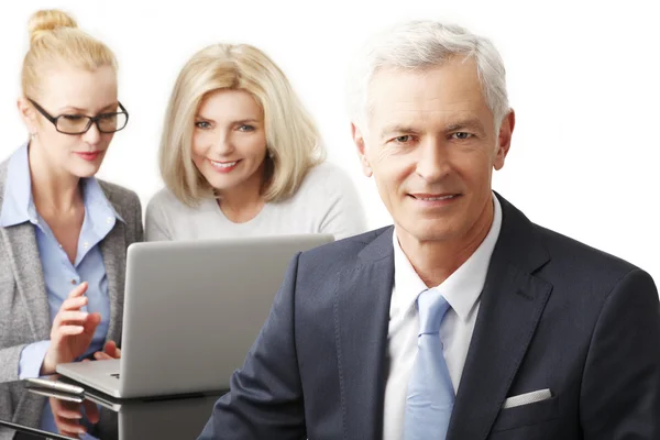 Geschäftsmann mit Frauen im Hintergrund — Stockfoto