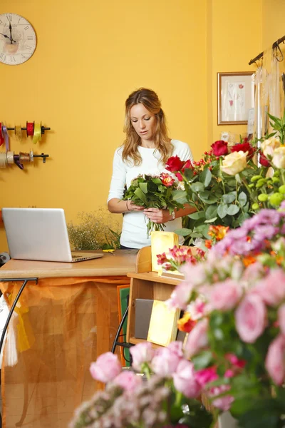 Florist kvinna som står vid hennes blomsteraffär — Stockfoto